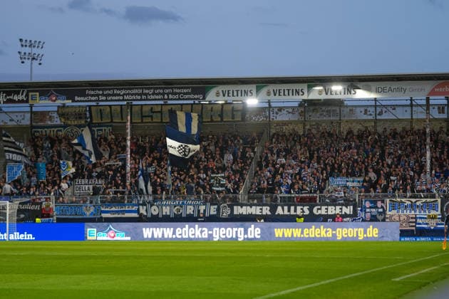 Deutschland: Fußball 3. Liga 2026 2027, 7. Spieltag - SV Wehen Wiesbaden vs MSV Duisburg - Brita-Arena (Wiesbaden): Zuschauer, Fans, Tribüne, Fahne, Transparent, Spruchband, Choreographie, Fanchoreo, von MSV Duisburg Copyright: xTobiasxWentzellx