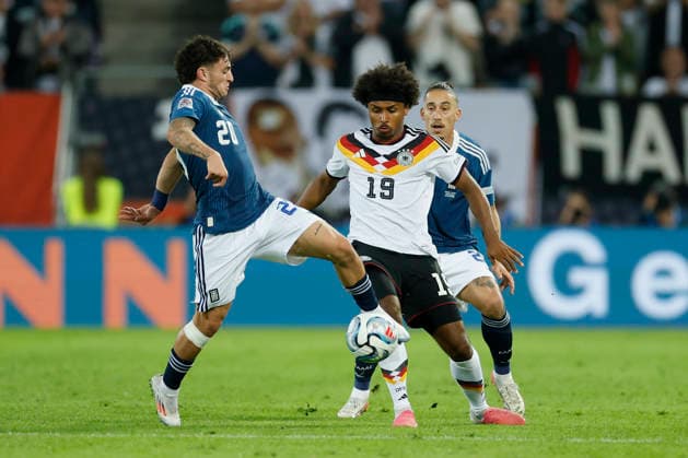 v.l.n.r.: Christos Zafeiris (Griechenland), Karim Adeyemi (Deutschland) und Kostas Tsimikas (Griechenland), im UEFA-Nations-League-Spiel zwischen Deutschland und Griechenland in der WWK Arena, Augsburg, Deutschland, am 27. September 2026 in action during the UEFA Nations League match between Germany and Greece at the WWK Arena, Augsburg, Germany, on September 27, 2026. Copyright: HMBxMedia xHeikoxBecker