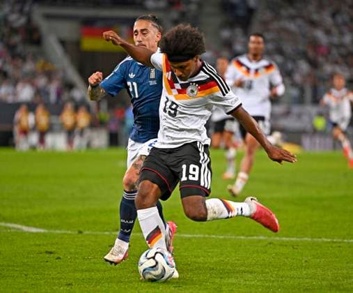 27.09.2026, Fussball UEFA Nations-League 2026 2027, 2.Spieltag, Deutschland - Griechenland, in der WWK-Arena Augsburg, v.l. Kostas Tsimikas (Griechenland) gegen Karim Adeyemi (Deutschland)