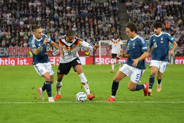 27.09.2026, xemx, Fussball UEFA Nations League, Deutschland - Griechenland v.l. Konstantinos Kostas Tsimikas (Griechenland) Kevin Schade (Deutsche Fussball Nationalmannschaft DFB) Panagiotis Retsos (Griechenland) Zweikampf, Aktion, action, battle for the ball Augsburg