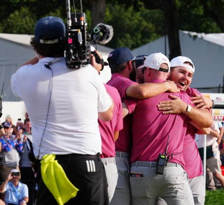 MEDINAH, IL - SEPTEMBER 27: Team USA golfers Cameron Young and Chris Gotterup hug team captain Brandt Snedeker on the 18th green when USA clinches the Presidents Cup during the round five singles matches of the 2026 Presidents Cup on September 27, 2026, at Medinah Country Club in Medinah, Illinois. (Photo by Brian Spurlock Icon Sportswire) GOLF: SEP 27 Presidents Cup EDITORIAL USE ONLY Icon26092763