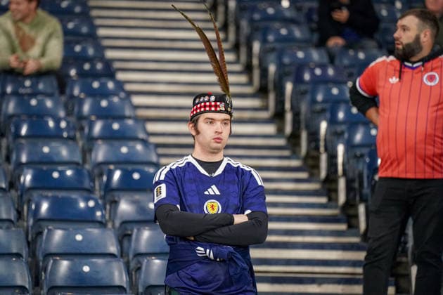 Fussball UEFA Nations League 2026 - 2027, 2. Spieltag - Schottland vs Schweiz - Hampden Park (Glasgow): Schottischer Fan im Hampden Park beim Spiel Schottland gegen Schweiz. Der Zuschauer trägt das Trikot der schottischen Nationalmannschaft sowie eine traditionelle schottische Kopfbedeckung mit langen Federn. Fussball, UEFA Nations League, Schottland, Schweiz, Fan, Zuschauer, Fankultur, Porträt, Tribüne, Nationaltrikot, Schottland-Trikot, Kopfbedeckung, Tradition, Tartan, Federn, Hampden Park, Glasgow. Copyright: xJOERANxSTEINSIEKx