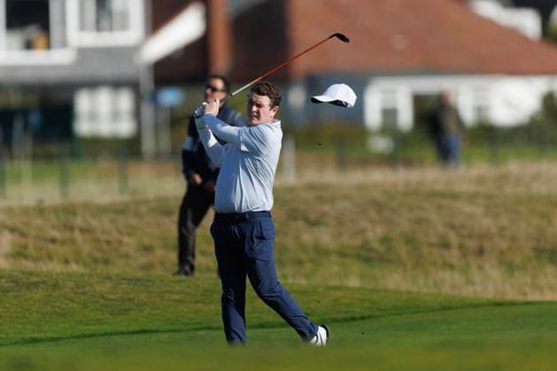 1st October 2026; Carnoustie Golf Links, Carnoustie, Angus, Scotland; DP World Tour Golf, Alfred Dunhill Links Championship, Day 1; Robert Macintyre of Scotland loses his hat in the wind as he plays a shot from the fairway on the seventeenth hole DavidxYoung