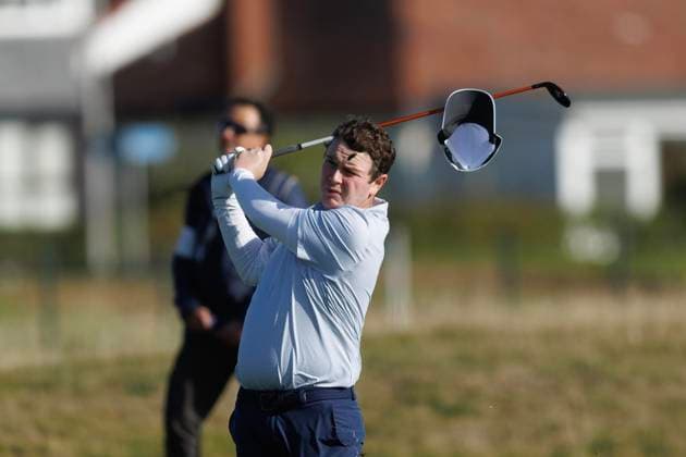 1st October 2026; Carnoustie Golf Links, Carnoustie, Angus, Scotland; DP World Tour Golf, Alfred Dunhill Links Championship, Day 1; Robert Macintyre of Scotland loses his hat in the wind as he plays a shot from the fairway on the seventeenth hole DavidxYoung