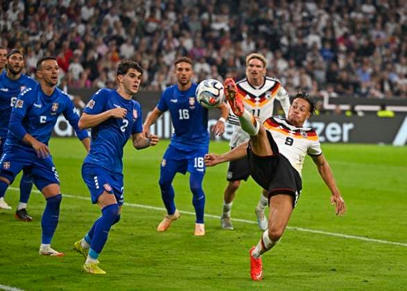 01.10.2026, Fussball UEFA Nations-League 2026 2027, 3.Spieltag, Deutschland - Serbien, in der Allianz-Arena München. v.l. Kosta Ndeljkovic (Serbien) gegen Derry Scherhant (Deutschland)