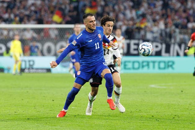 Filip Kostic (11, Serbien) und Mika Baur (14, Deutschland) beim Spiel zwischen Deutschland v Serbien, Fussball, Herren, UEFA Nations League, 2026 2027, 3.Spieltag am 01.10.2026 in München, Allianz Arena. Bayern Deutschland