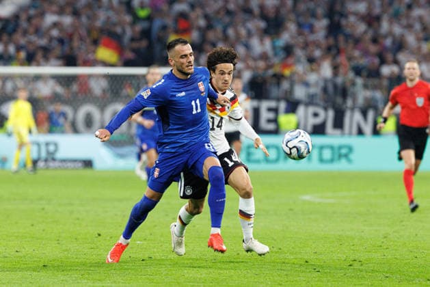 Filip Kostic (11, Serbien) und Mika Baur (14, Deutschland) beim Spiel zwischen Deutschland v Serbien, Fussball, Herren, UEFA Nations League, 2026 2027, 3.Spieltag am 01.10.2026 in München, Allianz Arena. Bayern Deutschland