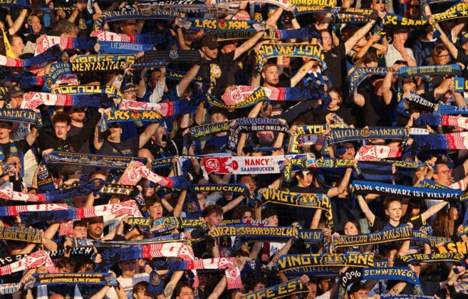 02.10.2026, Fussball, Herren, Testspiel, Saison 2026 2027, 1. FC Saarbrücken - AS Nancy-Lorraine, Fans des 1. FC Saarbrücken halten ihre Schals hoch und singen gemeinsam das Vereinslied Saarbrücken Ludwigsparkstadion Saarland Deutschland Copyright: xFabianxKleerx