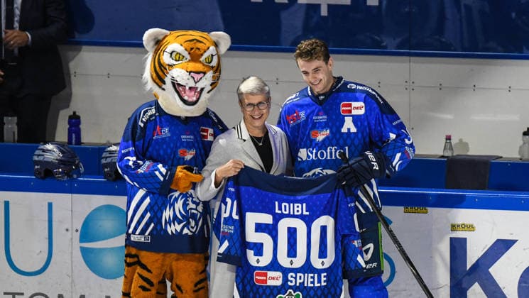 Stefan Loibl (Straubing Tigers) mit Gaby Sennebogen und Tigo bei der Ehrung zum 500. Spiel, Eishockey Herren, Deutsche Eishockey Liga, Penny DEL, 5.Spieltag, Saison 2026 2027 am 02.10.2026 im Eisstadion am Pulverturm, Straubing Tigers (blau) gegen Pinguins Bremerhaven (weiss)