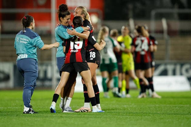 Fußball I Frauen I Saison 2026-2027 I Bundesliga I Bayer 04 Leverkusen - Werder Bremen I 02.10.2026 Lobke Loonen (18, Bayer 04 Leverkusen) und Loreen Bender (19, Bayer 04 Leverkusen) freuen sich zusammen mit dem Trainerteam über den Sieg Leverkusen Ulrich-Haberland-Stadion Nordrhein-Westfalen Deutschland Copyright: xLobeca CedricxSiefkerx