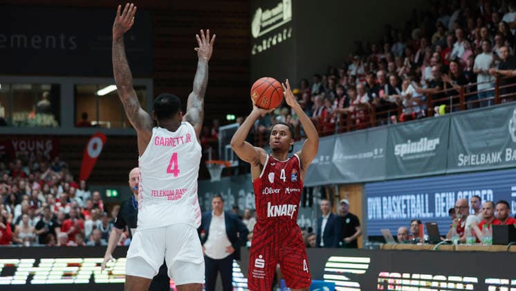Im Bild: v.li. Jeff Garrett Jr. (Telekom Baskets Bonn, 4) gegen den Dreipunktewurf von Sam Griffin (Wuerzburg Baskets, 4) kurz vor Schluss 02.10.2026, Fitness First Wuerzburg Baskets vs. Telekom Baskets Bonn, easyCredit BBL, 4. Spieltag, Deutschland, 97072, tectake-Arena Wuerzburg, Copyright: HMBxMedia xJulienxBecker