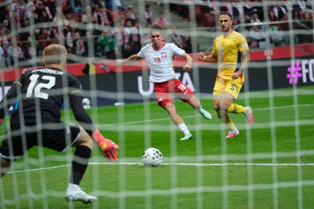 October 2, 2026, Warsaw, Masovian Voivodeship, Poland: Poland s MARCEL REGULA (18) and Romania s VIRGIL GHITA (5) and goalkeeper OTTO HINDRICH (12) in action during a UEFA Nations League Group B4 match between the Polish and Romanian national teams at the PGE Narodowy Stadium in Warsaw. Poland went on to win against Romania 6 goals to 0. Soccer 2026: UEFA Nations League: Poland 6:0 Romania  - ZUMAk204 20261002_zip_k204_060 Copyright: xRomanxKozielx