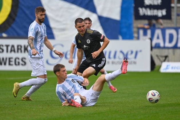 Mirko PUSCHER(AN) Aktion,Zweikampf gegen Emre ERDOGAN (1860 Muenchen). Li:Eric UHLMANN (1860 Muenchen) Fussball Regionalliga Bayern Saison 2026 2027,26 27 12.Spieltag TSV 1860 Muenchen - SpVgg Ansbach am 03.10.2026 in Muenchen GRUENWALDER STADION.
