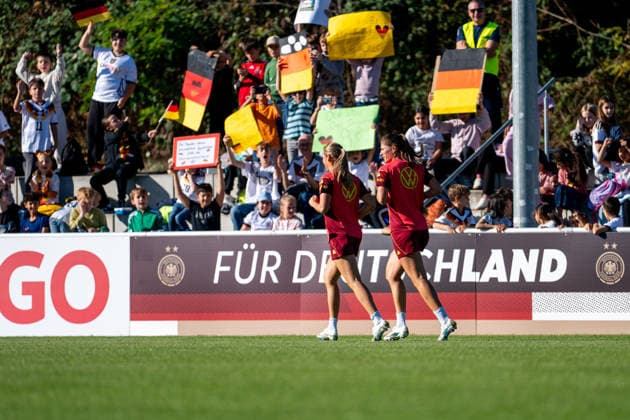 06.10.2026, GER, Fussball, Frauen, Training, DFB Nationalmannschaft Deutschland Marie Müller ( Deutschland ), Melissa Kössler ( Deutschland ), dahinter Fans Schulkinder des Badischen Fußballverband auf der Tribüne mit Fahnen und Plakaten Heidelberg ASV Eppelheim Baden-Württemberg Deutschland Copyright: xNordphoto Memmlerx