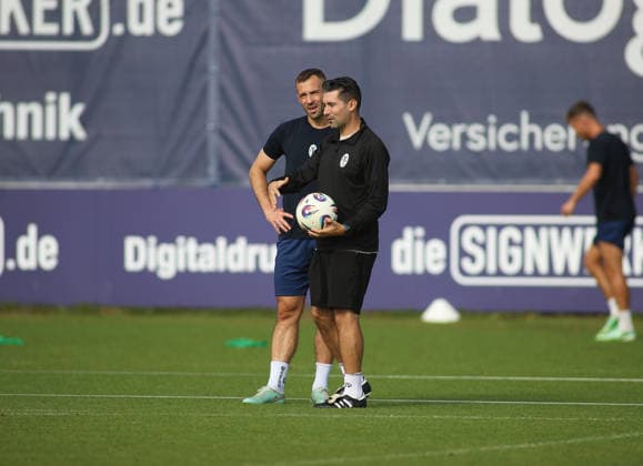 Fussball, Herren, Regionalliga Bayern, Saison 2026 2027, TSV 1860 München, Training, Grünwalder Strasse 114 Felix Weber (TSV 1860 München) (li.) mit Alper Kayabunar, Trainer (TSV 1860 München) (re.) zusammen stehend auf dem Spielfeld im Gespräch