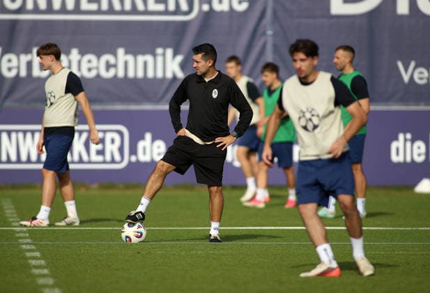 Fussball, Herren, Regionalliga Bayern, Saison 2026 2027, TSV 1860 München, Training, Grünwalder Strasse 114 Alper Kayabunar, Trainer (TSV 1860 München) mit einem Fuss auf dem Ball auf dem Trianingsplatz stehend, beobachtet seine Spieler