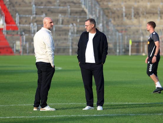 Fussball, Herren, Toto-Pokal, Viertelfinale, Saison 2026 2027, SpVgg Unterhaching - SSV Jahn Regensburg, Sportpark Unterhaching Dr.Alexander Schmalhofer, Sportdirektor (SSV Jahn Regensburg) (li.) mit Sascha Hildmann, Trainer (SSV Jahn Regensburg) (re.) im Gespräch auf dem Spielfeld stehend