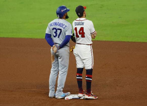 Los Angeles Dodgers Teoscar Hernandez (37) and Atlanta Brave Mauricio Dubon (14) watch a replay review after a call on second base in the sixth inning in an MLB, Baseball Herren, USA National League Division Series playoff game at Truist Park in Atlanta, Georgia, on Wednesday, October 7, 2026.  ATL20261007718 MIKExZARRILLI