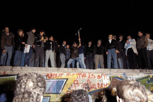 Berliner zerstören mit der Spitzhacke die Berliner Mauer