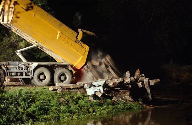Freiwillige Helfer schütten Betonteile von einem LKW und versuchen einen Deichdurchbruch bei Heyrothsberge im Landkreis Jerichower Land zu verschließen