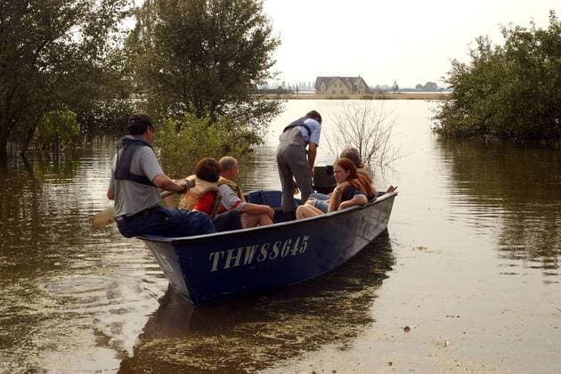Mitarbeiter des THW setzen Anwohner des Örtchens Gübs in einem Boot über