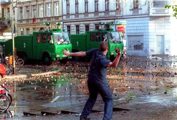 1. Mai-Krawalle am Mariannenplatz in Berlin-Kreuzberg - Randalierer wirft mit Steinen nach den Wasserwerfern der Polizei