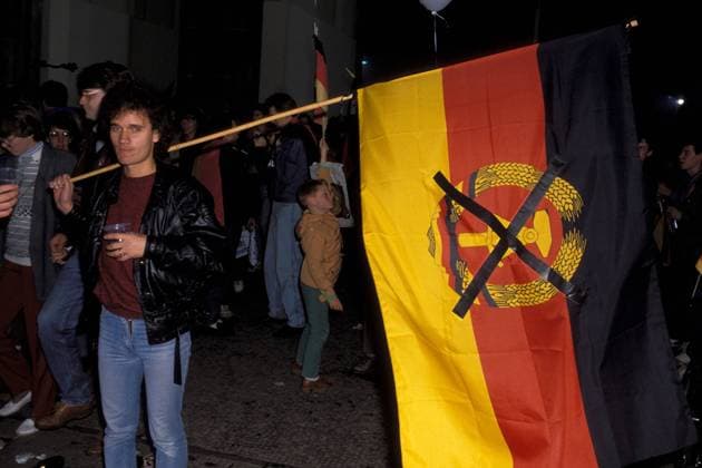 Wiedervereinigungsfeier: Mann mit DDR-Flagge mit durchgestrichenem Wappen