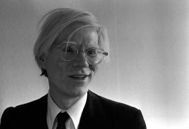 Künstler Andy Warhol (USA) lächelt