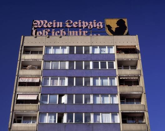 Leuchtreklame auf einem Platten-Neubau zitiert den Goethe-Spruch -Mein Leipzig lob ich mir- in Leipzig