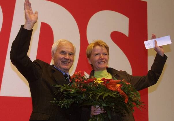 Gabi Zimmer (re., GER PDS-Bundesvorsitzende) und Hans Modrow (GER PDS-Ehrenvorsitzender) mit Blumenstrauß gut gelaunt vor dem PDS-Logo auf dem Bundesparteitag der PDS in Gera