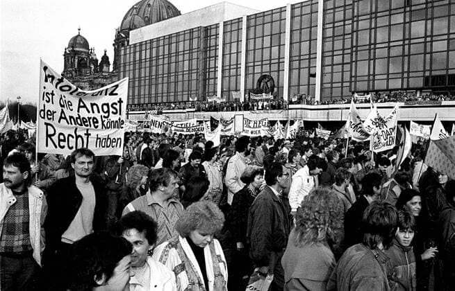 1989 - Friedliche Revolution! Demonstranten marschieren unter der Losung WIR SIND DAS VOLK am Palast der Republik in Berlin-Mitte vorbei und fordern Demokratie sowie freien Wahlen