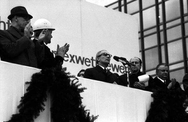 Erich Honecker (Mitte, GDR Staatsratsvorsitzender der DDR und Generalsekretär des Zentralkomitees der SED) hält eine Rede auf der Tribüne und die Genossen klatschen während des Richtfestes am Palast der Republik in Ost Berlin