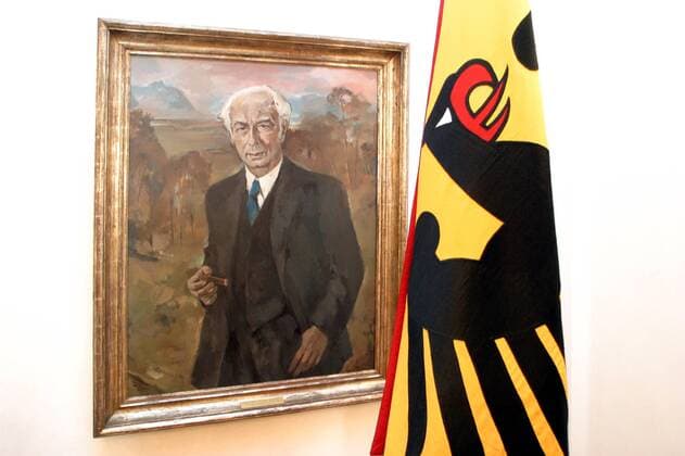 Porträt des ersten Bundespräsidenten Theodor Heuss neben einer Standarte mit dem Bundesadler in der Villa Hammerschmidt in Bonn