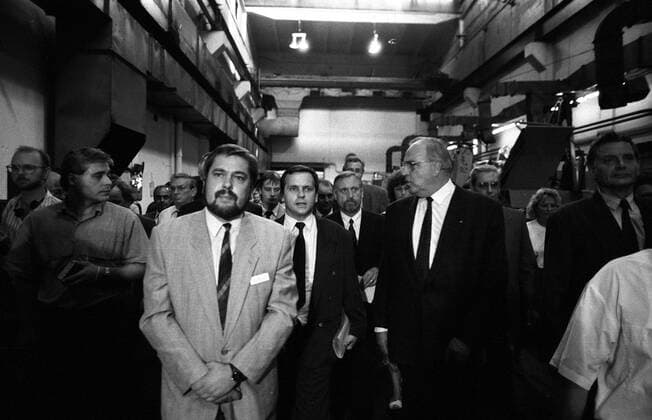 Bundeskanzler Helmut Kohl (re., GER CDU) im Gespräch mit Funktionären und Mitarbeitern in einer Werkhalle des VEB TRAKTORENWERKS während seines Besuches in Schönebeck