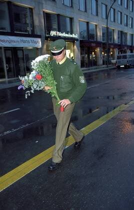 9 11 - Polizist trägt Blumen zur US-amerikanischen Botschaft im Gedenken an die Terroropfer