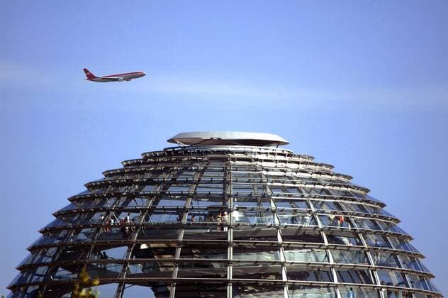 Flugzeug über der Reichstagskuppel in Berlin