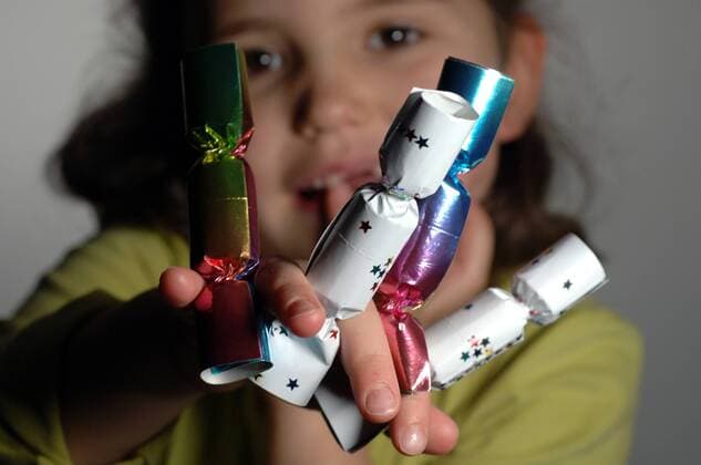 Kleines Mädchen spielt mit Knallbonbons - Silvesterknaller können in der Hand von Kindern gefährlich sein