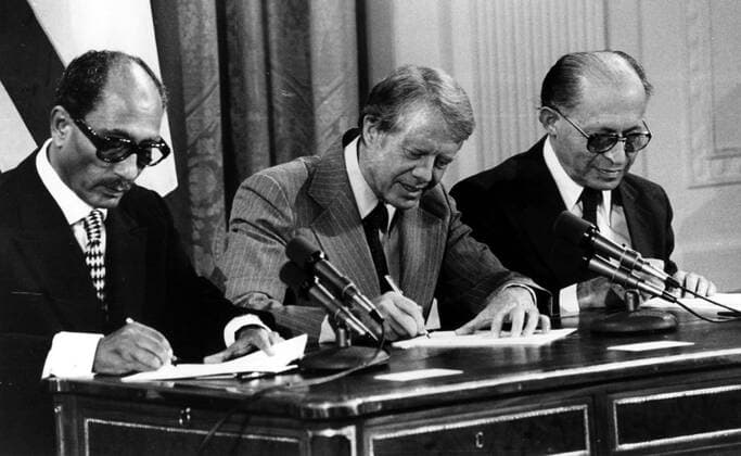 Präsident Jimmy Carter (Mitte, USA), Präsident Anwar as-Sadat (EGY) und Premierminister Menachem Begin (ISR) unterzeichen den Friedensvertrag Camp David I in Washington D.C. -  (CART2002101509)