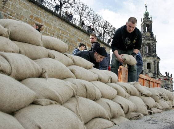 Freiwillige stapeln Sandsäcke zu einem Deich während des Hochwassers der Elbe in Dresden