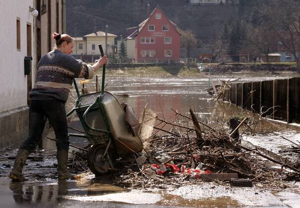 Aufräumarbeiten nach dem Hochwasser - Anna Lange aus Wehlen befreit nach dem Rückgang des Hochwassers ihr Grundstück von Treibgut