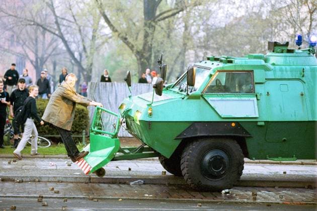 Mann klettert auf ein Polizeifahrzeug während des 1. Mai in Berlin-Kreuzberg