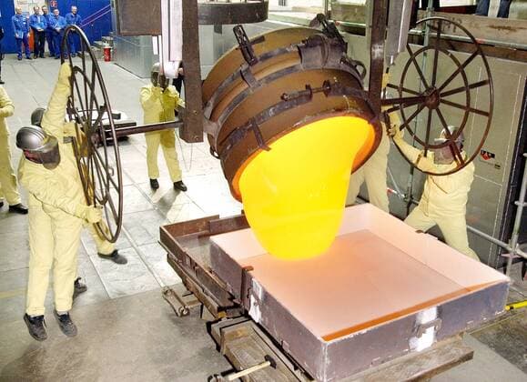 Mitarbeiter am Schmelztiegel das 900 Grad Celsius heiße Filterglas in ein Gefäß während der Nachstellung des ersten Gusses optischen Glases aus dem Jahre 1952 anlässlich des 50 jährigen Jubiläums im Werk der Schott AG in Mainz