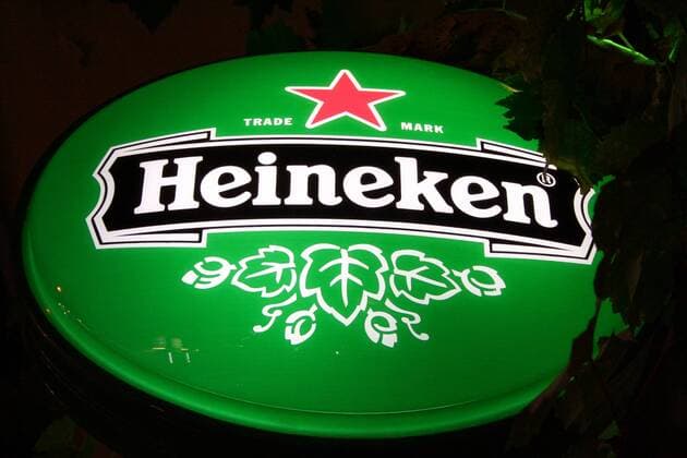 Nächtlich beleuchtetes Schild wirbt für Heineken Bier auf Sarti - Griechenland