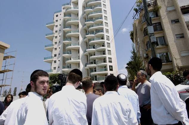 Junges Israelis betrachten den Schaden an einem Wohnhaus in Tiberias verursacht durch den Beschuss mit Katyusha-Raketen der libanesischen Hisbollah-Miliz -  JER2006071509