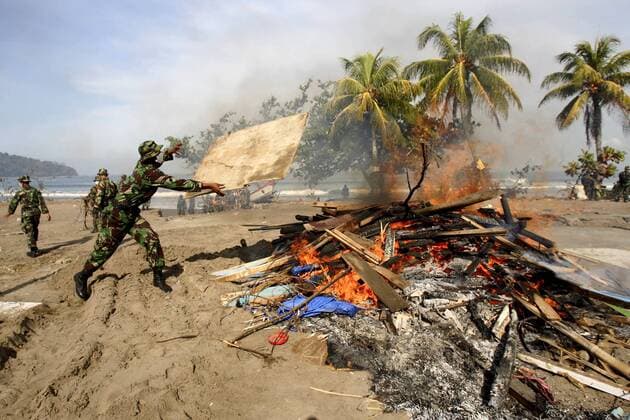 Indonesische Soldaten verbrennen während der Aufräumarbeiten Schutt nach dem verheerenden Tsunami in Pangandaran auf Java - 