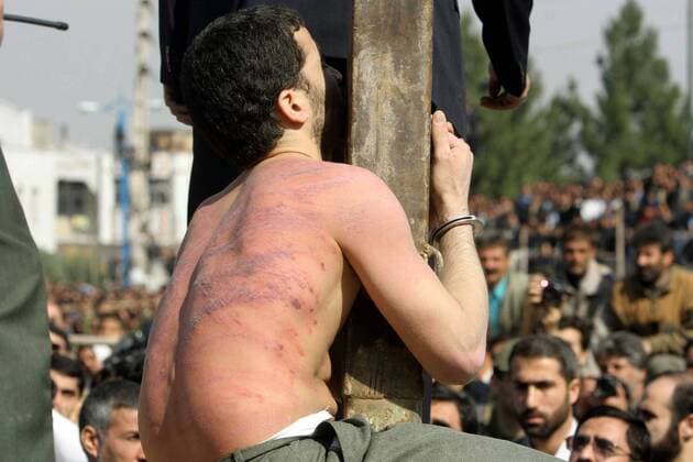 Mörder Mohammad Bijeh am Pranger umringt von Schaulustigen während seiner öffentlichen Auspeitschung vor seiner Erhängung in Pakdasht, Iran -  (wax20050316107)