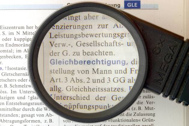 Begriff - Gleichberechtigung - in einem Wörterbuch durch eine Lupe gesehen