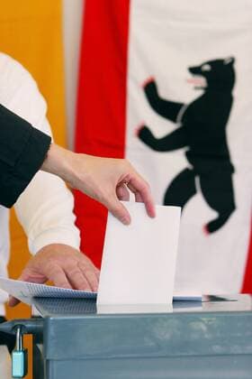 Wählerin steckt anlässlich der Bundestagswahlen in Berlin den Wahlzettel in die Urne