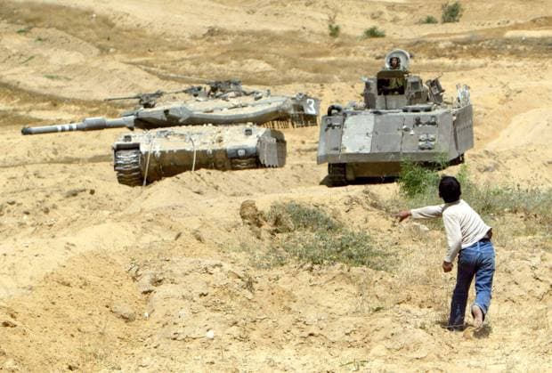 Palästinensischer Junge wirft Steine auf israelische Panzer in Beit-Lahya während Auseinandersetzungen zwischen Palästinensern und Israelischer Armee im Gaza-Streifen -  (GAZ2004042017)