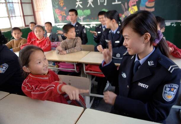 Polizistin Zhang Yaowen (CHN) im Gespräch mit einem Mädchen in einer Schule für Taubstumme Kinder in Hefei in der chinesischen Provinz Anhui - 